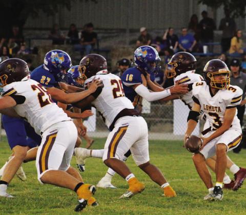 Jordan Livesay pitches the ball behind Lometa’s offensive line of, left to right, Roy Carr, Emmanuel Prado and Colten Whitehead. MASON HINES | DISPATCH RECORD