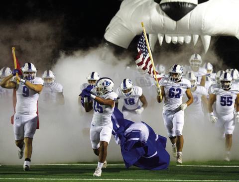 HUNTER KING | DISPATCH RECORD Brady Renfrew (9), Dailan Fagan (15) and Nick Torrez (62) lead the Badgers onto the field.