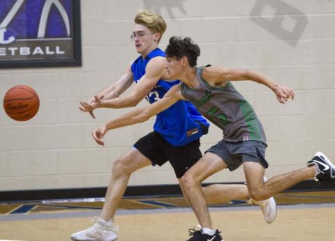 Cort Howard, left, and an opposing player race to the ball near the corner of the court in a recent game. JEFF LOWE | DISPATCH RECORD