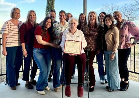 A group of Aggie Moms surrounds Carol Wright as she holds the club’s certificate recognizing its 35th anniversary. Wright was one of the founding members in 1990. COURTESY PHOTO