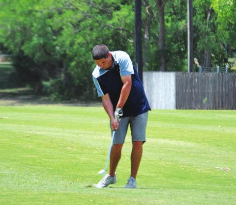 Shane Cazas makes contact with his approach shot on the fifth hole on Friday. HUNTER KING | DISPATCH RECORD