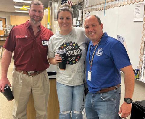Chandler Hail, center, was selected September Teacher of the Month. Administrators said the science teacher is tough but fun in the classroom, and she continues this love and high standards as a coach on the volleyball and basketball court. Clay Phillips, left, of Texas Farm Bureau Insurance was on hand for the recognition, along with Principal Paul Weinheimer. courtesy photo
