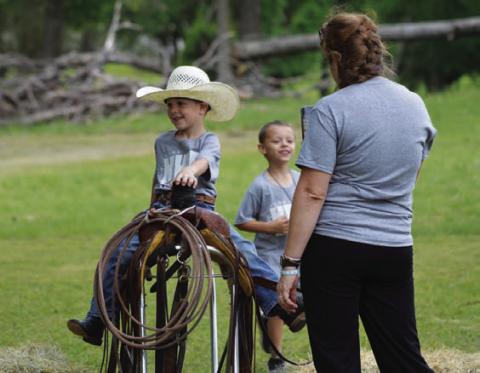 Kyler Harrell embraces his inner cowboy and climbs atop a saddle. ERICK MITCHELL | DISPATCH RECORD
