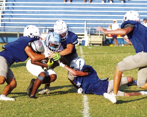 HUNTER KING | DISPATCH RECORD A group of Badgers are in on the tackle of the China Spring ball carrier.