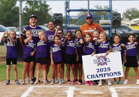 COURTESY PHOTO A young softball team shows off their rings from winning last season.