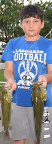Fabian Luna holds a 14-inch bass and a 16-inch bass he caught on Friday as part of a free fishing event hosted by the city of Lampasas. DAVID LOWE | DISPATCH RECORD