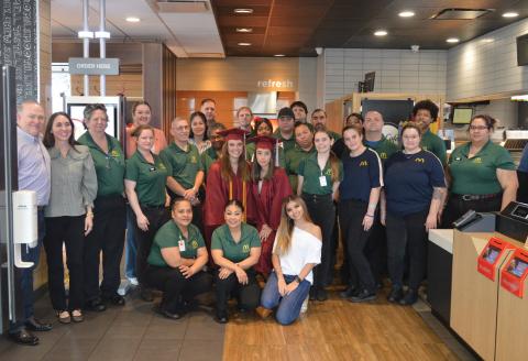 At center with their graduation gowns, Mary DeBellis and Maribel Rivera stand alongside the Lampaas McDonald’s team. Both DeBellis and Rivera received their college degrees through the McDonald’s Archways to Opportunity program. Erick Mitchell | dispatch record