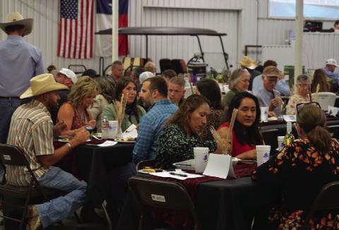 Reverse Raffle attendees gathered inside the show barn for dinner before live auction festivities got underway. ERICK MITCHELL| DISPATCH RECORD