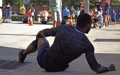 An athlete stretches in preparation for a competition outside of Houston. The assumption that daily exercise is the only requirement for an athlete negates the invisible percentage of work and effort such a lifestyle requires, including nutrition, programming, routine and rest. ALEXANDRIA RANDOLPH | DISPATCH RECORD