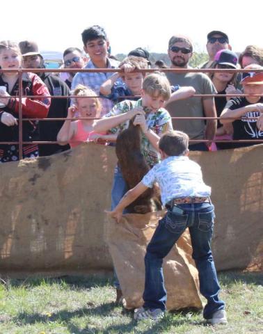 MASON HINES | DISPATCH RECORD Lucky Bumpas and Trig Bumpas captivated the audience during the junior division of the hog sacking contest.