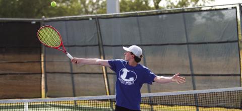 Elijah Copeland reaches for a backhand shot at Tuesday’s match against Leander Glenn. HUNTER KING | DISPATCH RECORD