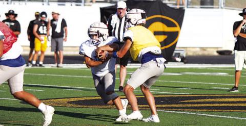 FILE PHOTO Bryson Roberts hands the ball to Daemian Rivas at the Badgers’ first scrimmage last week.