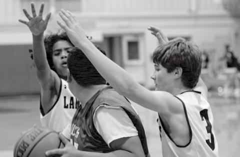 Angel Scott, back left, and Timber Gholson (3) trap a Taylor Duck in the Badgers’ eighth-grade “B” victory at home Thursday. JEFF LOWE | DISPATCH RECORD