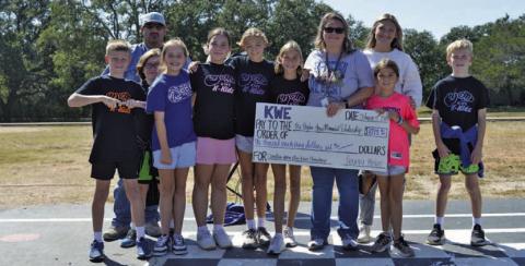 Kline Whitis Elementary School teacher Shante Seward holds a big check for $1,073.62. The funds were raised by Kline Whitis students for the Peyton Jones Memorial Scholarship. Jones, Seward’s son, died after a battle with leukemia several years ago. ERICK MITCHELL | DISPATCH RECORD