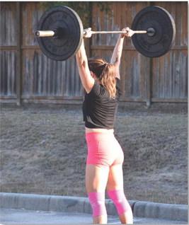A middle-aged woman lifts weights during a functional fitness competition in Houston. Competition is an enjoyable aspect of fitness that can encourage commitment to exercise. alexandria Randolph | dispatch record