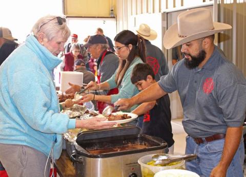 Lometa VFD member Paul Sanchez serves a member of the community during the annual barbecue fundraiser event. Mason hines | Dispatch Record