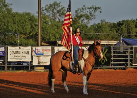 Rodeo Queen Hadyn Ferguson presents the American flag to the rodeo crowd. ERICK MITCHELL | DISPATCH RECORD