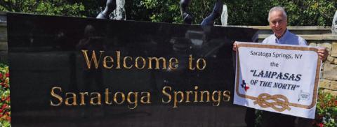 Former Lampasan Phil King is pictured on a recent visit to Saratoga Springs, New York, where he displayed his banner proclaiming it the “Lampasas of the North.” COURTESY PHOTO
