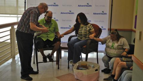 AdventHealth chaplain Jack Gilliland, at left, prays with Michael Miller, Brandy Watkins and Amy Miller in advance of next week’s transplant surgery. ERICK MITCHELL | DISPATCH RECORD