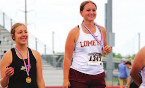 Sierra Tower stands atop the podium at the regional track meet after winning the discus event. JESSICA MALDONADO | DISPATCH RECORD