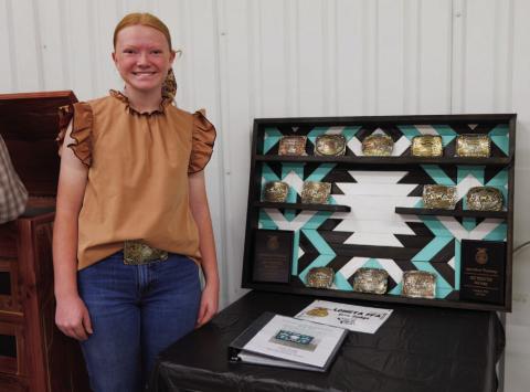 Lometa senior Selie Hodge poses for a photo with her 2026 ag mechanics project, a shelf to hold belt buckles aquired through livestock show competitions over the years. ADAM BARRIOS | DISPATCH RECORD