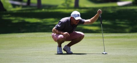 HUNTER KING | DISPATCH RECORD Golf coach Justin Schulze reads a putt during Saturday play at the Memorial Tournament.