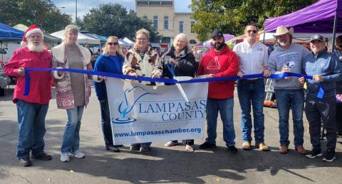 On hand for an official ribbon-cutting event last week were vendors, friends and Lampasas County Chamber of Commerce staff who welcomed Lampasas County Farmers Market &amp; Crafts to the downtown courthouse square. Holding the ceremonial scissors is Arlene Banks, co-organizer of the market. courtesy photo