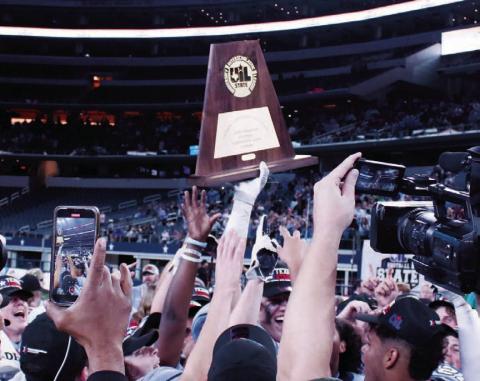 The state championship trophy is lifted high by a victor from 2022. FILE PHOTO