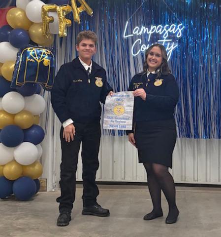 Mason Luna receives his Star Greenhand award from FFA officer Trinity Watkins. Luna garnered the award for his work in Agribusiness. COURTESY PHOTO