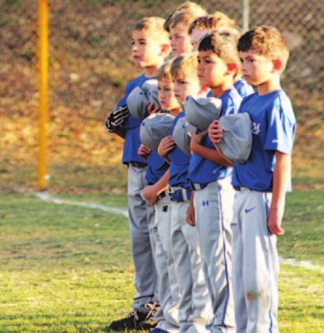 Youth ball players stand for the national anthem on opening day. COURTESY PHOTO