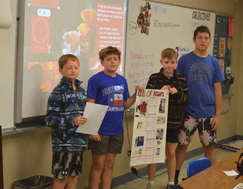 From left are students Kash Kreider, Shade Clouds, Trigg Hill and Bentley Larsen as they present their Bill of Rights poster during class on Wednesday. Erick Mitchell | Dispatch Record