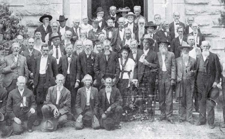 A group of Confederate veterans lined up for the camera on the south side entrance to the Lampasas County Courthouse. Instead of gray uniforms, many of the old men wore gray beards. Date of the photo is unknown. keystone square museum files