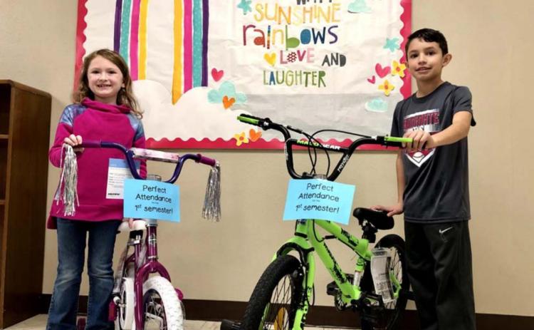 Second-grade student Emerson Evans, left, and fourth-grade student Nolan Clary had their names selected to receive a bicycle from among those students who earned perfect attendance recognition for the first semester of the 2020-2021 school year. COURTESY PHOTO