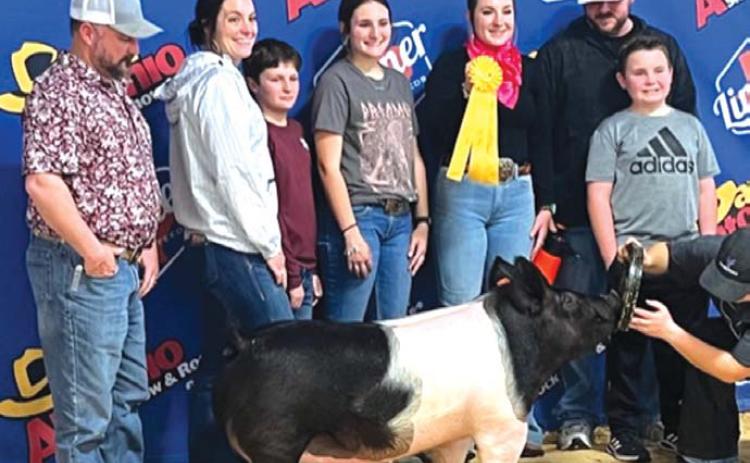Lampasas FFA member Avery Hopson, center, took fifth place with her heavyweight dark crossbred hog at the San Antonio Livestock Show. court esy photo