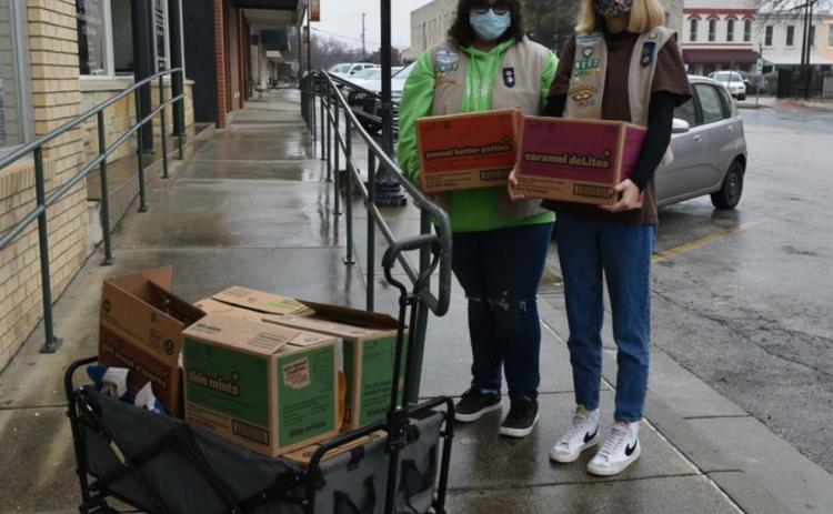 Maggie Ochsner, left, and Charlotte Carmack, members of Lampasas Girl Scout Unit 712, prepare to sell cookies to businesses on the courthouse square on the first day of their selling season. MADELEINE MILLER | DISPATCH RECORD