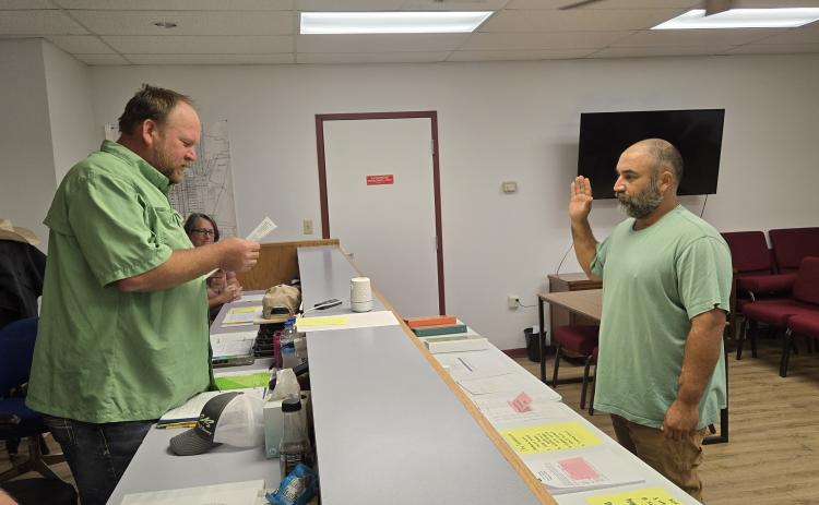 Lometa Mayor Derek Talley, left, administers the oath to council member Alex Witherspoon who will serve as mayor pro tem, while newly appointed council member Christine Eltgroth looks on during Monday night’s meeting.