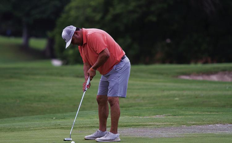 Harvey Stinnett hits a putt during the KM two-man scramble at Hancock Park Golf Course last Friday. HUNTER KING | DISPATCH RECORD