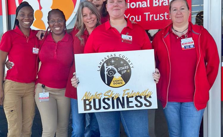 Employees, from left to right, Takira Green, Krystal Waters, Chris Wade, Connie C., Ashly Gilmore and Heather LaRue display the placard naming their store a Night Sky Friendly Business. courtesy photo