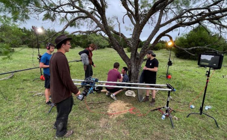 A film crew based out of Des Moines, Iowa gathers around a tree on the Crain/VanNatta-8-Ranch in Lampasas County while working on its production of “Big Iron.” COURTESY PHOTO