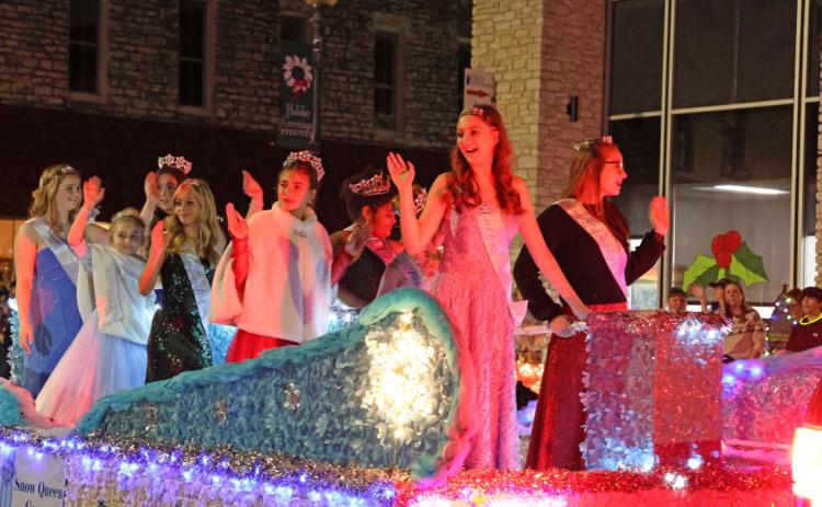 The 2023 Snow Queen Court waves to the crowd during the Carol of Lights Holidazzle Parade on Saturday. The Snow Queen Court was selected earlier that day during a pageant at the courthouse bandstand. JOYCESARAH MCCABE | DISPATCH RECORD