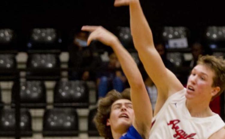 Landon Mulcahy, left, tips off against 6’7” Argyle senior Nate Atwood in the area championship, which Argyle won 65-45. JEFF LOWE | DISPATCH RECORD
