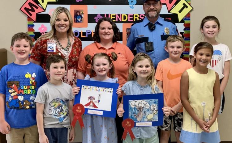 Honored for their participation in the annual Rabies Awareness &amp; Prevention Poster Contest were these Kline Whitis Elementary students: from left, Greyson Moore, Parker Mosebar, Kylee Davis, Ava Latham, Jeb Patterson, Sadie Walker and Hallie Watson. Pictured with them are Principal Leanne Bobo, back row at left, Animal Control Officer Kasey Schwartzer and Animal Control Officer Joseph Schwartzer. COURTESY PHOTO