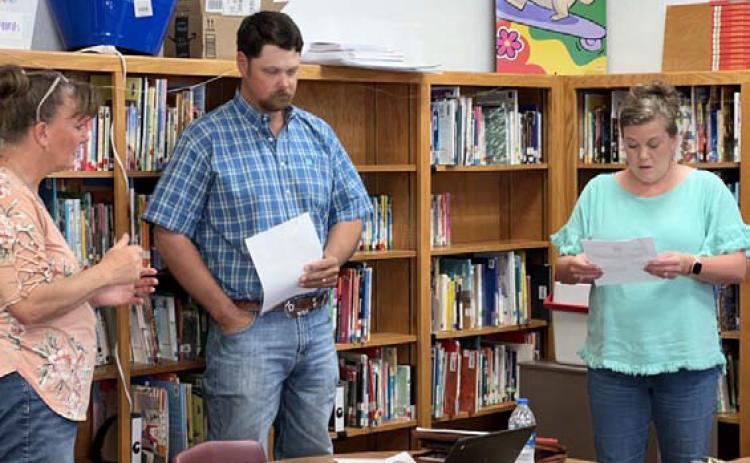 Lometa ISD Business Manager Ronda Bridges, left, administers the oath of office to school board trustees Dusty Duncan and Cristopher Brister. MASON HINES | DISPATCH RECORD