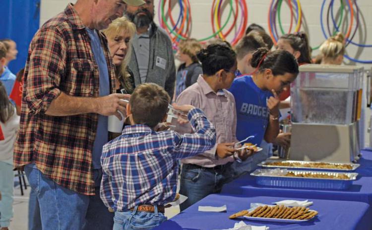 Students involved in the Hanna Springs Elementary School student leadership group “World Changers” assist veterans with their coffee, tea and cookies during Thursday’s Veterans Day reception. erick mitchellE | DISPATCH RECORD