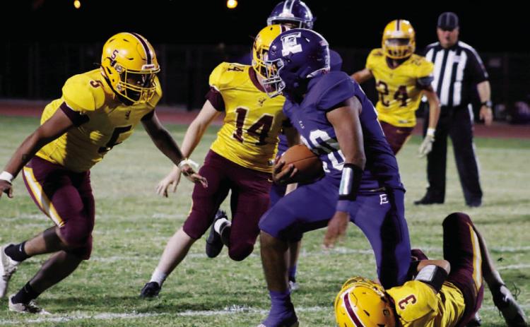 Jordan Livesay (3) wrangles an Eden ball carrier, while Elijah Gonzales (5) and Colton Whitehead (14) pursue. MASON HINES | DISPATCH RECORD