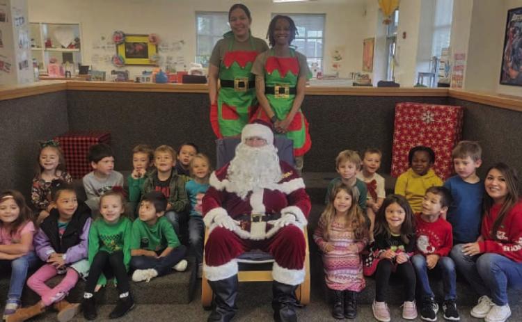Mrs. Mickan’s kindergarten class poses for a photo with Santa Claus and two of his elves. COURTESY PHOTO