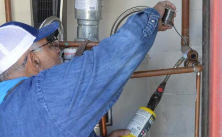 Lampasas ISD Maintenance Department employee Jesse Ramirez solders a copper line at the former Lampasas Middle School campus after record cold caused a leak. JEFF LOWE | DISPATCH RECORD
