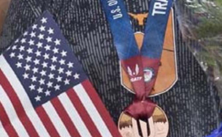 Steffin McCarter is shown with the American flag and his bronze medal at the Olympic Trials in Eugene, Oregon, last weekend. COURTESY PHOTO