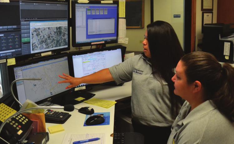 Lampasas Police Department communications personnel Mary Mendez, left, and Danicka Keeling look over maps and data relating to 911 calls. Some of the equipment pictured will be replaced as the police department updates its communications equipment. FILE PHOTO