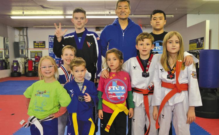 Master Chung Lee, center, stands alongside students from his Lampasas taekwondo studio on Monday. ERICK MITCHELL | DISPATCH RECORD